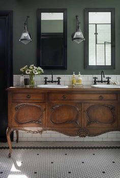 a bathroom with two sinks and mirrors on the wall next to each other in black and white tiles