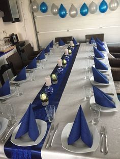 the table is set with blue and silver place settings