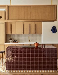 a kitchen with wooden cabinets and tile counter tops, along with an island in the middle