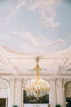 a chandelier hanging from the ceiling in a room with white walls and ceilings