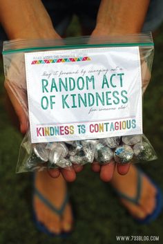 a person holding a bag of candy with the label reading random act of kindness on it