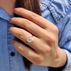 a close up of a person wearing a ring with an oval shaped diamond on it