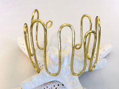 This boho style bracelet features a heavy gauge gold plated wire that has been lightly hammered into a wavy design. It's slightly adjustable so there's no need for a clasp! Note: Each bracelet is made to order so will be similar but slightly different than pictured. Also the wire is slightly flexible so will be shipped in a box for added protection. Gold Brass Bracelets For The Beach, Gold Brass Bracelet For The Beach, Adjustable Gold Bohemian Cuff Bracelet, Gold Adjustable Cuff Bracelet, Womens Gift Ideas, Bracelet Tutorials, Hammered Cuff Bracelet, Red Bangles, Silver Pearl Bracelet