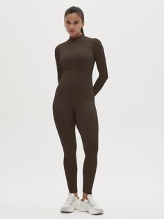 Why We Love It: The Hannah Long Sleeve Zipper Bodysuit is the epitome of sleek, modern activewear. This bodysuit combines functionality with a streamlined design, ensuring you look and feel your best whether you're at the gym or out and about. Fit and Features: Front Zipper Detail: The front zipper allows for easy wear and adjustability, adding a chic element to this versatile piece. Long Sleeves with Thumbholes: Provides added coverage and a secure fit, perfect for cooler weather or intense workouts. Buttery Soft Fabric: This bodysuit feels like a second skin, offering unmatched comfort and flexibility. High Performance: The four-way stretch material ensures maximum freedom of movement, making it ideal for any activity. Moisture-Wicking Technology: Keeps you dry and comfortable, no matter Sleek Stretch Bodysuit For Sports, Sleek Sports Bodysuit Stretch Fit, Sleek Sports Bodysuit With Stretch, Sleek Stretch Sports Bodysuit, Sleek High Stretch Solid Unitard, Sleek High-stretch Solid Color Unitard, Sleek High-stretch Unitard, Sporty Fitted Unitard For Loungewear, Sleek High Stretch Unitard