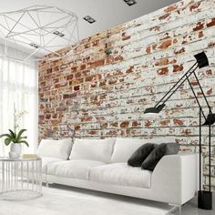 a living room with brick walls and white furniture