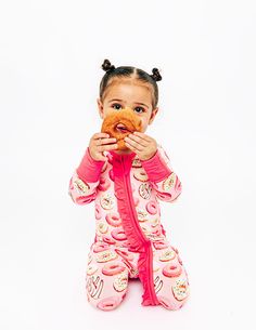 Get ready for sweet dreams with this A-dough-rable print. The vibrant donuts on this pajama set adds a touch of whimsy and sweetness that your little one will love. Designed to be as soft as cuddles, this convertible footie is made with the coziest, snuggliest bamboo viscose fabric. Our footie features fold-over foot cuffs and mittens, so you can easily transition from sleep to play. The stretchy fit and the luxurious fabric feel gentle on your baby’s delicate skin, while the 2-way double zipper Playful Pink Onesie For Pajama Party, Playful Pink Onesie For Sleep, Playful Long Sleeve Onesie For Sleepovers, Sweet Pink Sleepwear For Sleepover, Pink Cotton Onesie For Pajama Party, Playful Pink Onesie For Playwear, Pink Sweet Sleepwear For Bedtime, Sweet Pink Sleepwear For Bedtime, Playful Cotton Onesie For Pajama Party