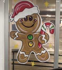 a large cut out of a ginger with a santa hat and candy cane in front of a window