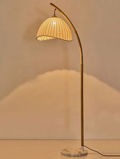 a floor lamp with a white shade on it's base and a round light bulb