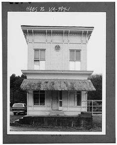 an old black and white photo of a house with a car parked in front of it