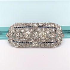 This is a stunning vintage Art Deco era diamond bar brooch/pendant. The brooch is made of platinum.   The piece contains a total of 10.99 Carats of old European cut diamonds with synthetic sapphire accents. Please see the attached appraisal for the full details of the diamonds. This is in Perfect condition.  Appraisal is included. If you have any questions or would like to see additional pictures, please contact us before making your purchase. Buyers outside the United States, please contact us Bar Brooch, Diamond Bar, European Cut Diamonds, Art Deco Era, Vintage Diamond, Vintage Art Deco, Vintage Art, Brooches, Diamond Cuts