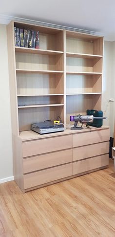 an empty room with bookshelves and drawers