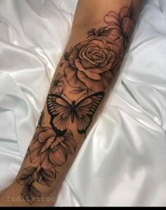 a woman's leg with flowers and a butterfly on it