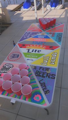 a table that has some cups on top of it and is decorated with different colors