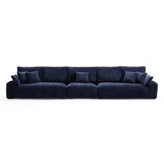 a large blue couch with pillows on the back and arms, in front of a white background