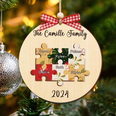 a personalized christmas ornament hanging from a tree with puzzle pieces on it