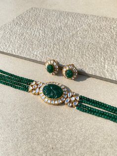 Sabyasachi-inspired Emerald Polki Necklace Set, a stunning blend of tradition and sophistication. This Green Kundan and Emerald-adorned choker, crafted with finesse in Jadau Jewelry style, captivates with its intricate design. The Uncut Polki gems and Uncut Kundan embellishments enhance its opulence, making it a perfect choice for special occasions. Elevate your style quotient with this exquisite Green Polki Choker Set that exudes timeless elegance and reflects the essence of classic charm. *𝐏? Festive Temple Jewelry Choker For Reception, Elegant Festive Choker With Zari Work, Traditional Green Choker For Reception, Festive Temple Jewelry Choker With Cutdana, Elegant Festival Choker With Zari Work, Elegant Zari Work Choker For Festivals, Festive Cutdana Choker For Reception, Festive Bollywood Choker With Zari Work, Festive Temple Jewelry Choker With Zari Work