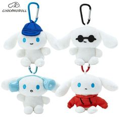 three small stuffed animals are hanging from keychain hooks, one is white and the other is blue