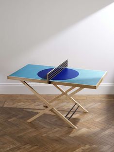 a ping pong table in the middle of a room with hard wood flooring