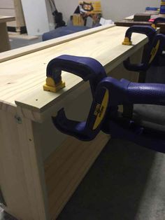 a pair of pliers are attached to the back of a workbench