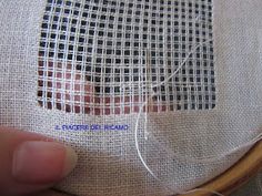 someone is stitching together some thread on a piece of fabric in a wooden hoop