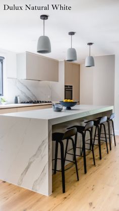 an island in the middle of a kitchen with bar stools