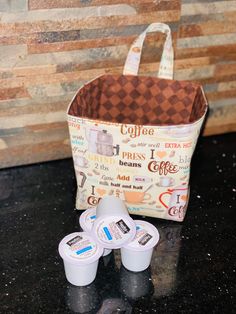 coffee cups are sitting on the counter next to a bag