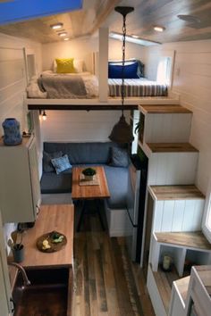 the interior of a tiny house with stairs leading up to the loft bed and kitchen