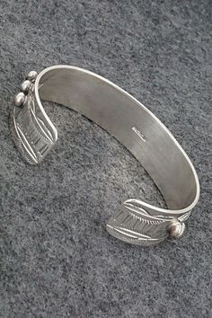 This beautiful coral and bright polished finish sterling silver bracelet was made by Navajo silversmith Wilbur Myers. The back is signed WM and sterling.Size: 5 3/4" (will fit up to a 6 7/8" wrist)Gap: 1 1/8"Width: 5/8"Free shipping on all orders! We ship with USPS and always include tracking. All orders ship within a day of payment.Returns are accepted up to 30 days after you receive your order. Just send us a message. Our shop offers cash back or store credit. The item must be returned in new condition. Southwestern Sterling Silver Polished Bangle Bracelet, Southwestern Sterling Silver Bangle With Polished Finish, Southwestern Polished Sterling Silver Bangle, Silver Southwestern Style Bracelet With Oyster Clasp, Silver Southwestern Style Oyster Bracelet, Southwestern Style Silver Oyster Bracelet, Artisan Sterling Silver Bracelet With Oyster Detail, Artisan Sterling Silver Oyster Bracelet, Sterling Silver Bracelet