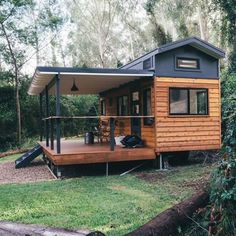 a small wooden cabin sitting on top of a lush green field