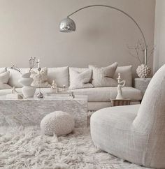 a living room filled with white furniture and pillows on top of a shaggy carpeted floor