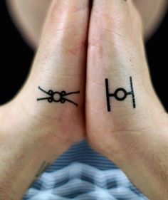 two people with tattoos on their hands are holding each other's hands in front of them