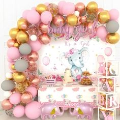 a pink and gold baby shower party with elephant balloons, cake table and wall decorations