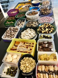 a table topped with lots of trays of food next to each other on top of a counter