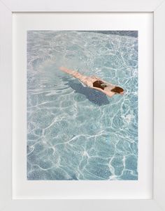 a man swimming in a pool with his back to the camera