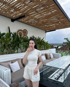 a woman standing in front of a couch on top of a roof