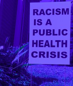 a sign that says racism is a public health crisis