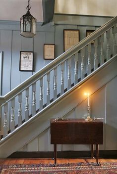 a table with a lit candle on top of it in front of a stair case