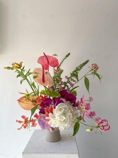 a vase filled with lots of different colored flowers