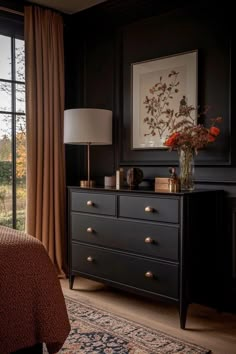 a bed room with a neatly made bed and a dresser next to a large window