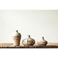 three vases sitting on top of a wooden table