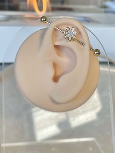 a pair of ear piercings sitting on top of a glass stand