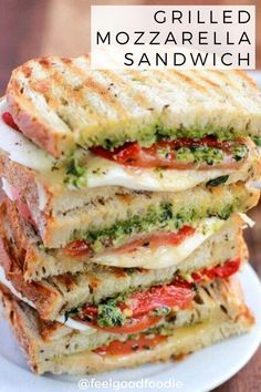 grilled mozzarella sandwich stacked on top of each other with tomatoes and pesto