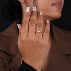 a close up of a person with a ring on their finger and wearing a brown coat