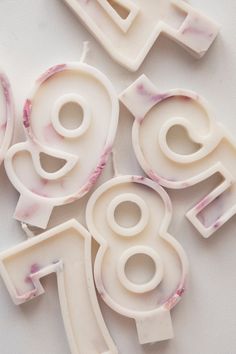 three white plastic numbers with pink flowers on them