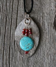 a necklace with a turquoise stone and red beads