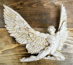 a white angel statue sitting on top of a wooden floor