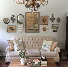 a living room with a couch, coffee table and chandelier hanging on the wall