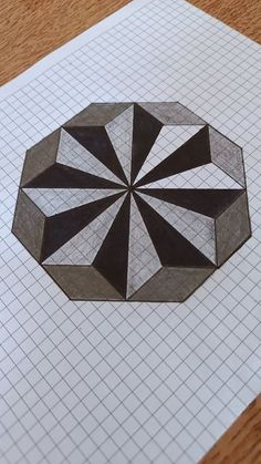 a piece of paper that is on top of a sheet of graph paper with a drawing of a geometric design