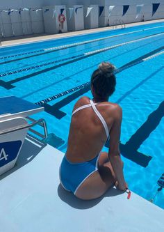 a woman sitting on the edge of a swimming pool