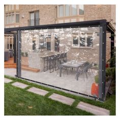 an outdoor dining area in front of a house with large windows and sliding glass doors